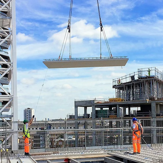 Site crew directing a crane lift in full protective equipment